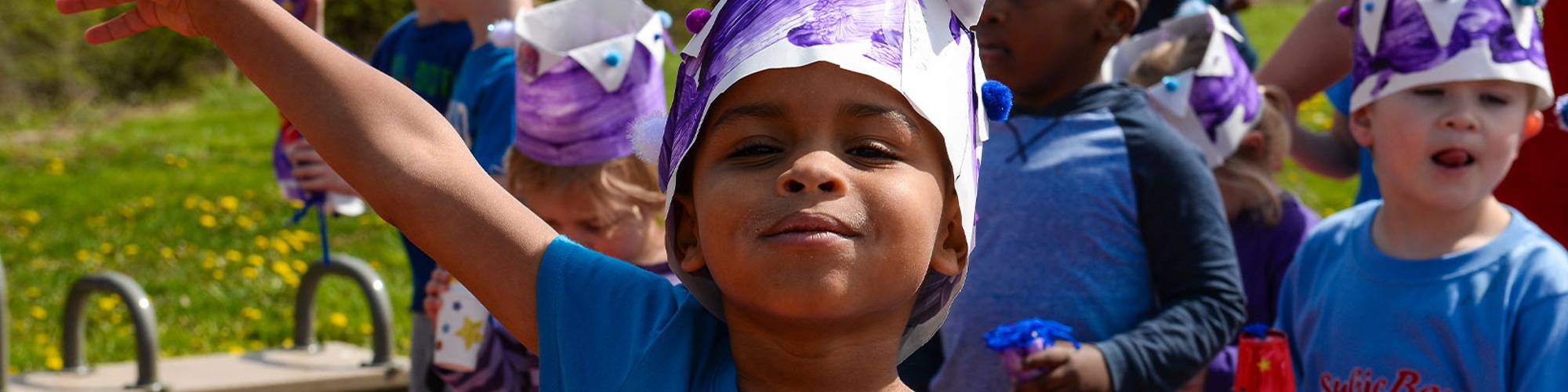 a child with purple paper on head