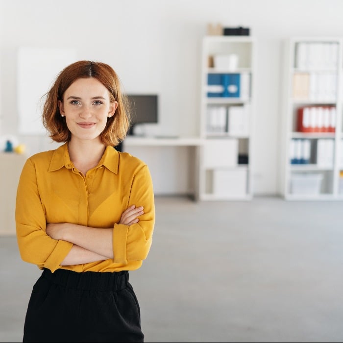 a person with red hair wearing a yellow shirt and black pants